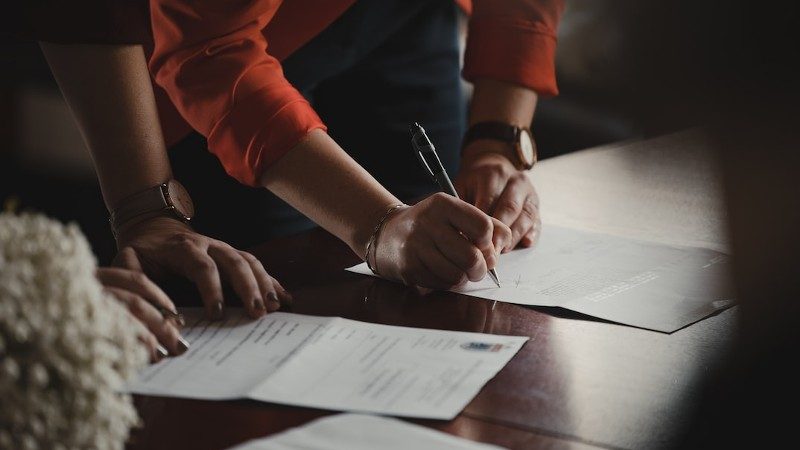 Signing paperwork. Image by Romain Dancre from Unsplash